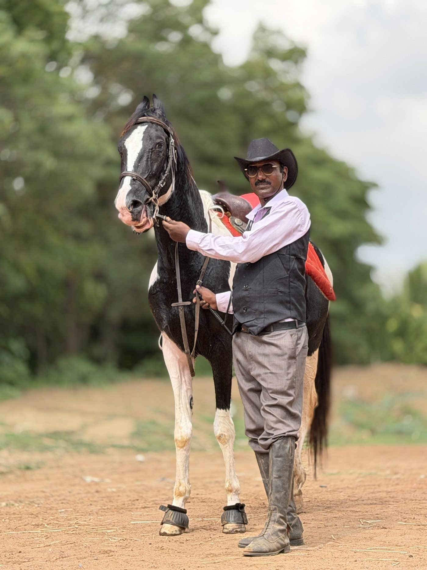Save Native Horses Trust trainer standing with a native black-and-white pinto horse