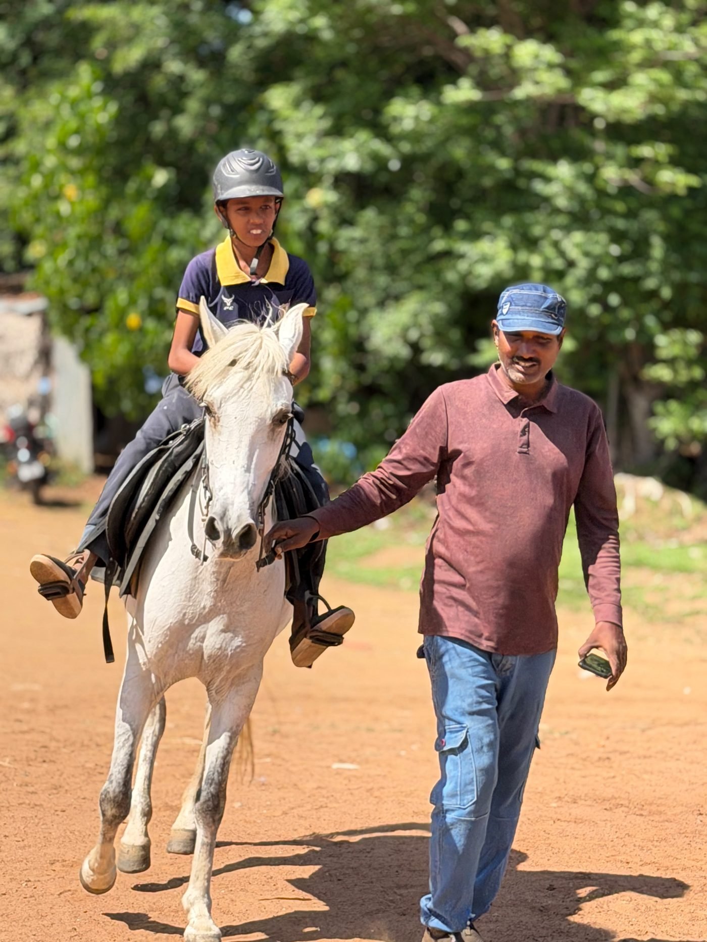 Trainer leading a mounted student along a trail in Trichy