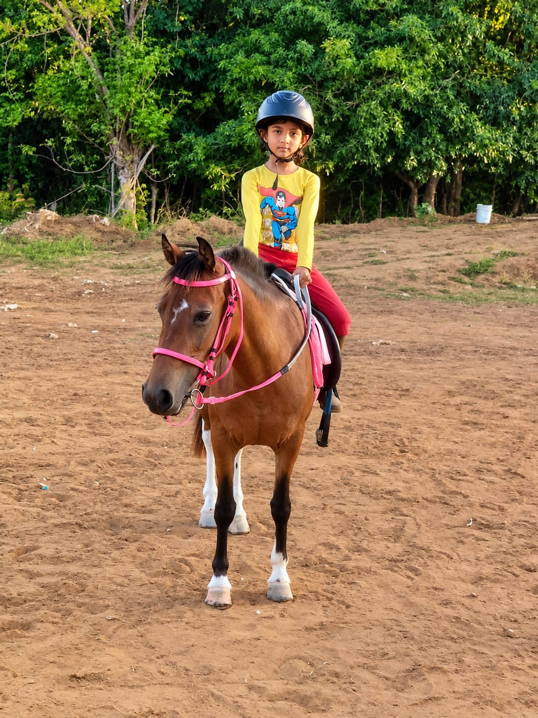 Child in riding helmet on a native pony during training